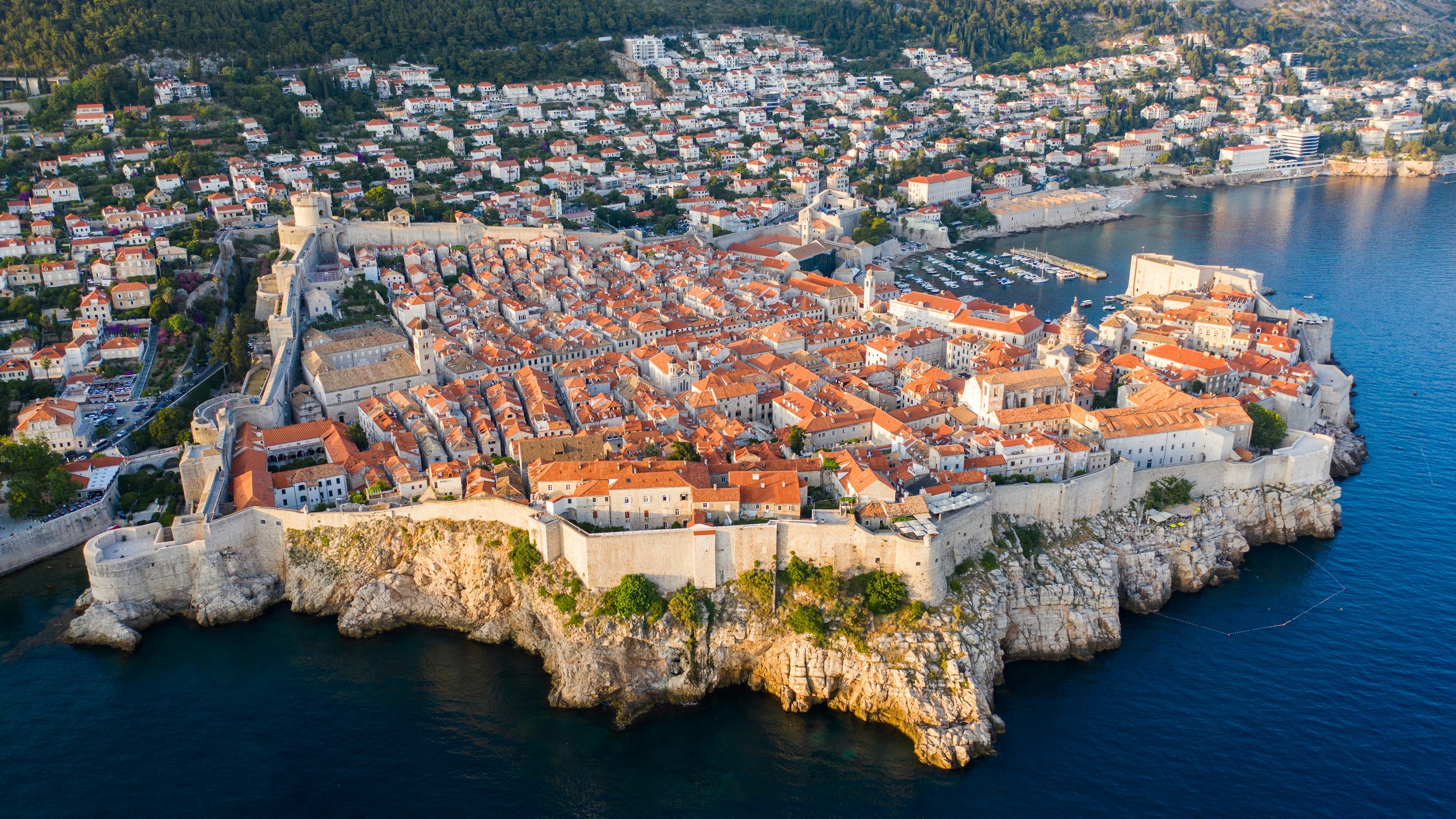 Golden hour aerial view of Dubrovnik old town, terracotta rooftops and Adriatic harbour, Dalmatia Croatia